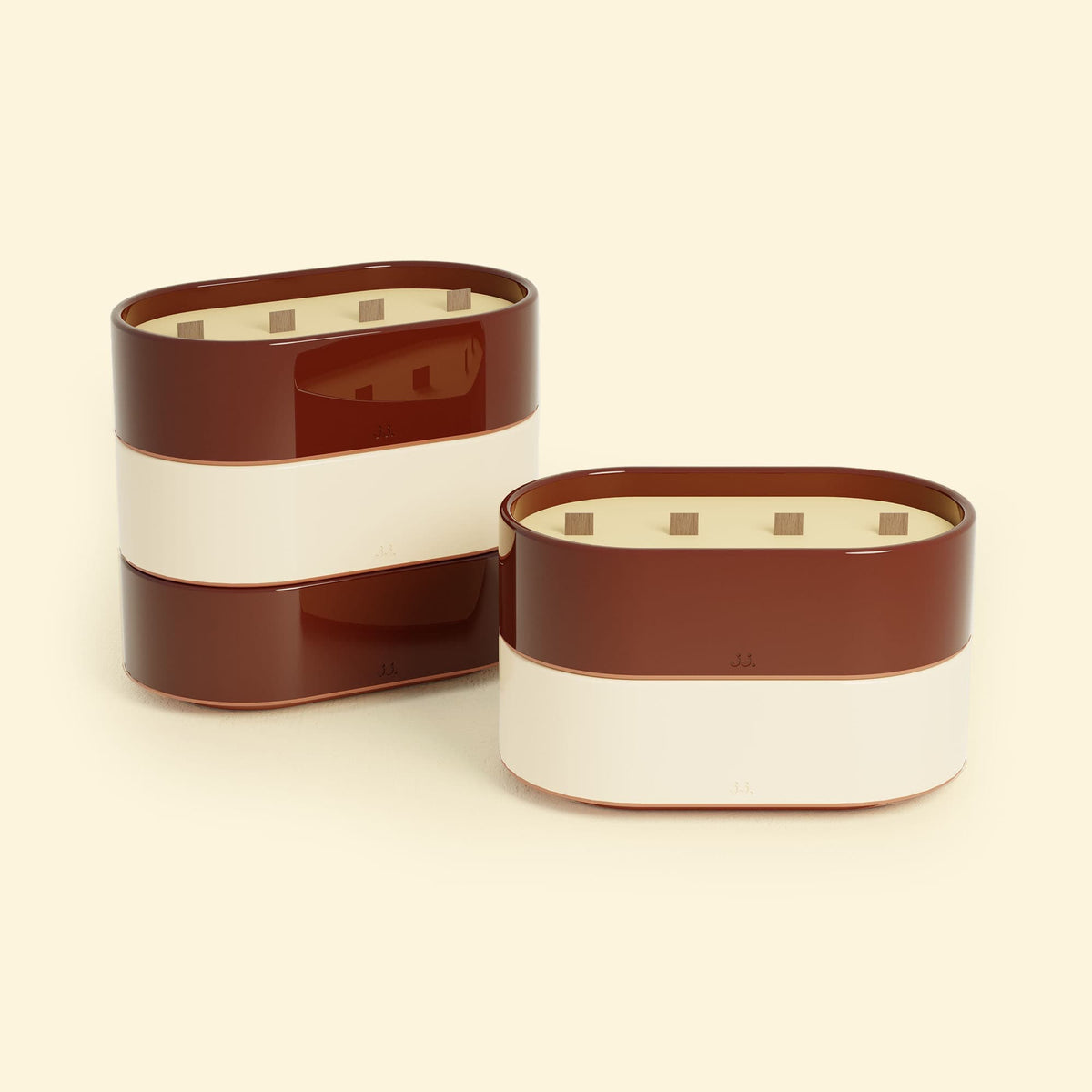 Bougies Totem L Rouge oxyde – Citronnelle & Géranium et Beige ivoire – Citronnelle & Citron, deux grandes bougies ovales à triple mèche en bois, posées sur un fond beige clair.