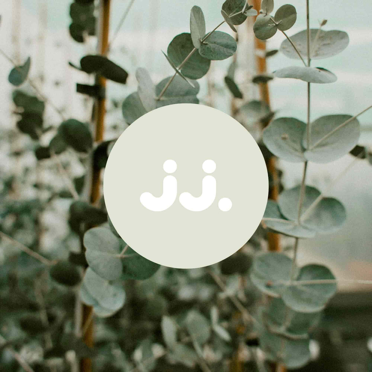 Feuilles d’eucalyptus vertes avec logo jj., symbolisant la senteur Citronnelle & Eucalyptus. 
