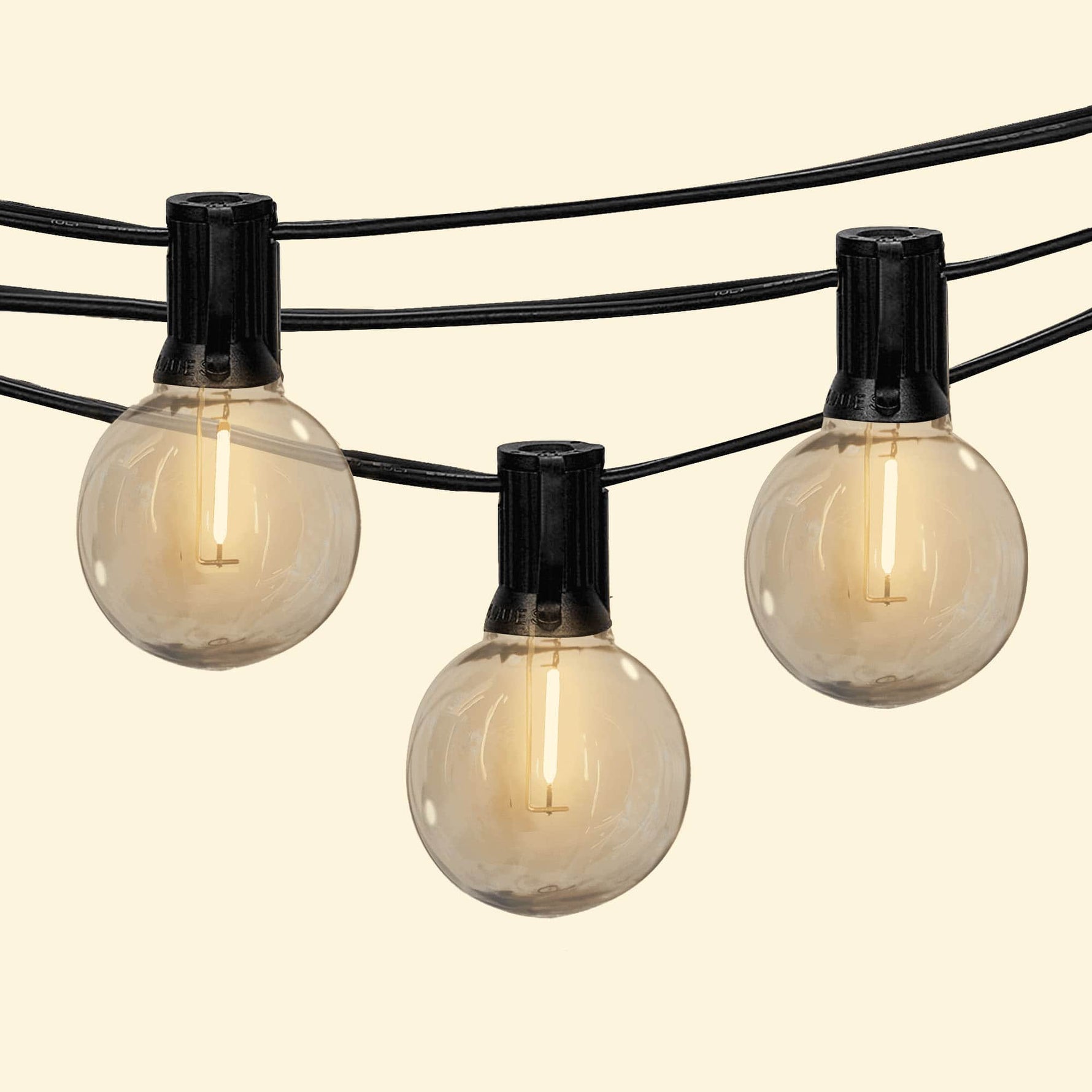 Guirlande lumineuse Goya avec ampoules rondes transparentes diffusant une lumière chaude, idéale pour une ambiance douce en extérieur.