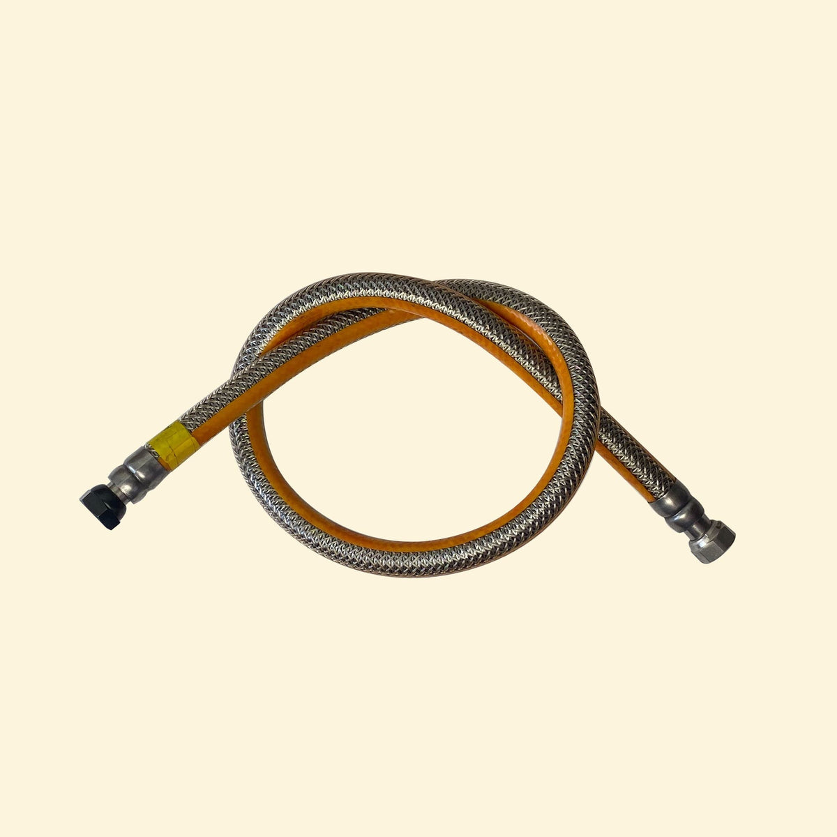 Tuyau de gaz renforcé inox pour plancha, avec embouts métalliques, présenté en boucle sur fond beige.