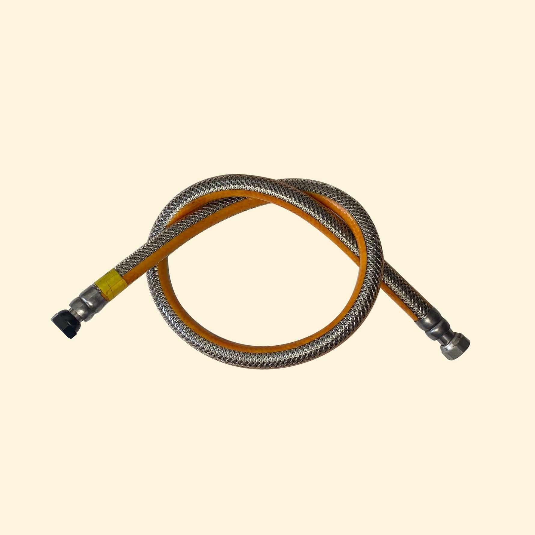 Tuyau de gaz renforcé inox pour plancha, avec embouts métalliques, présenté en boucle sur fond beige.